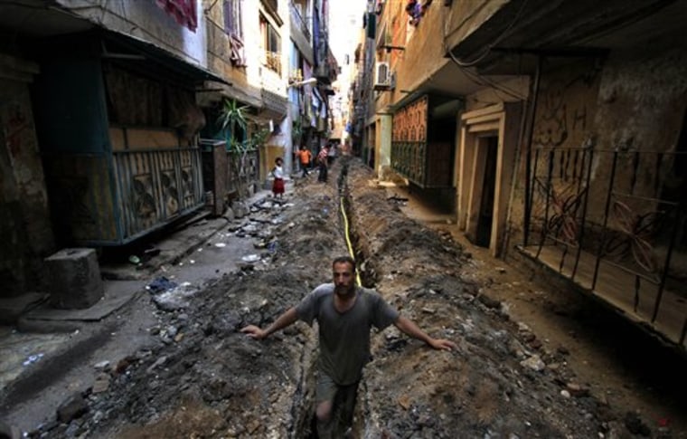 A worker stands in a ditch for a cooking gas line in an alley in the crowded neighborhood of Mit Oqba in Cairo. All over Egypt, dozens of Popular Committees have sprouted, each dedicated to bringing the can-do spirit of Egypt's revolution to a neighborhood. But the committees are running up against former local officials under the Mubarak regime who still hold considerable power, showing that the old regime is alive and well in the new Egypt. 